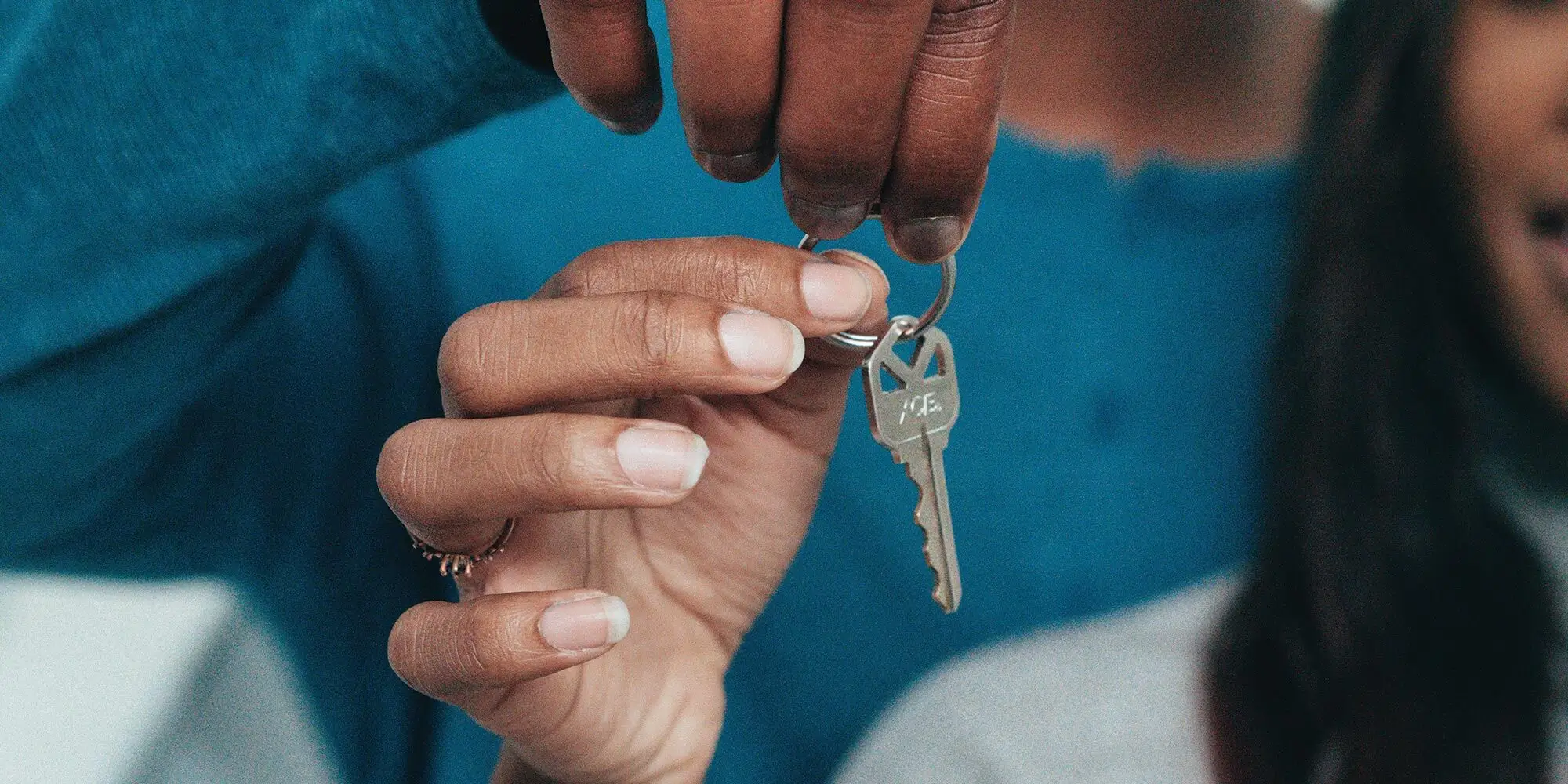 Hands holding house key.